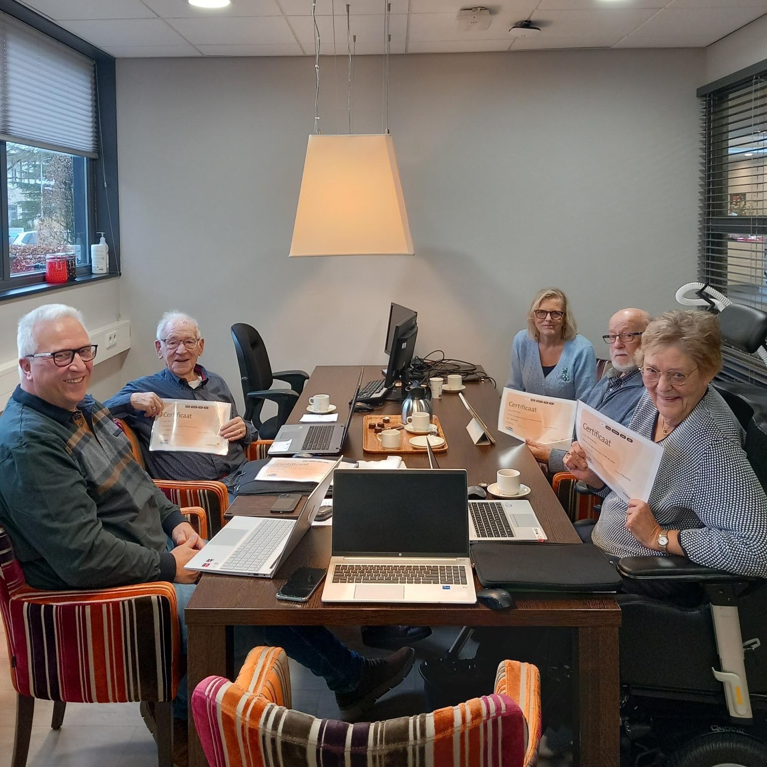 Deelnemers van een cursus voor laptop hebben allemaal een certificaat in hun handen. 