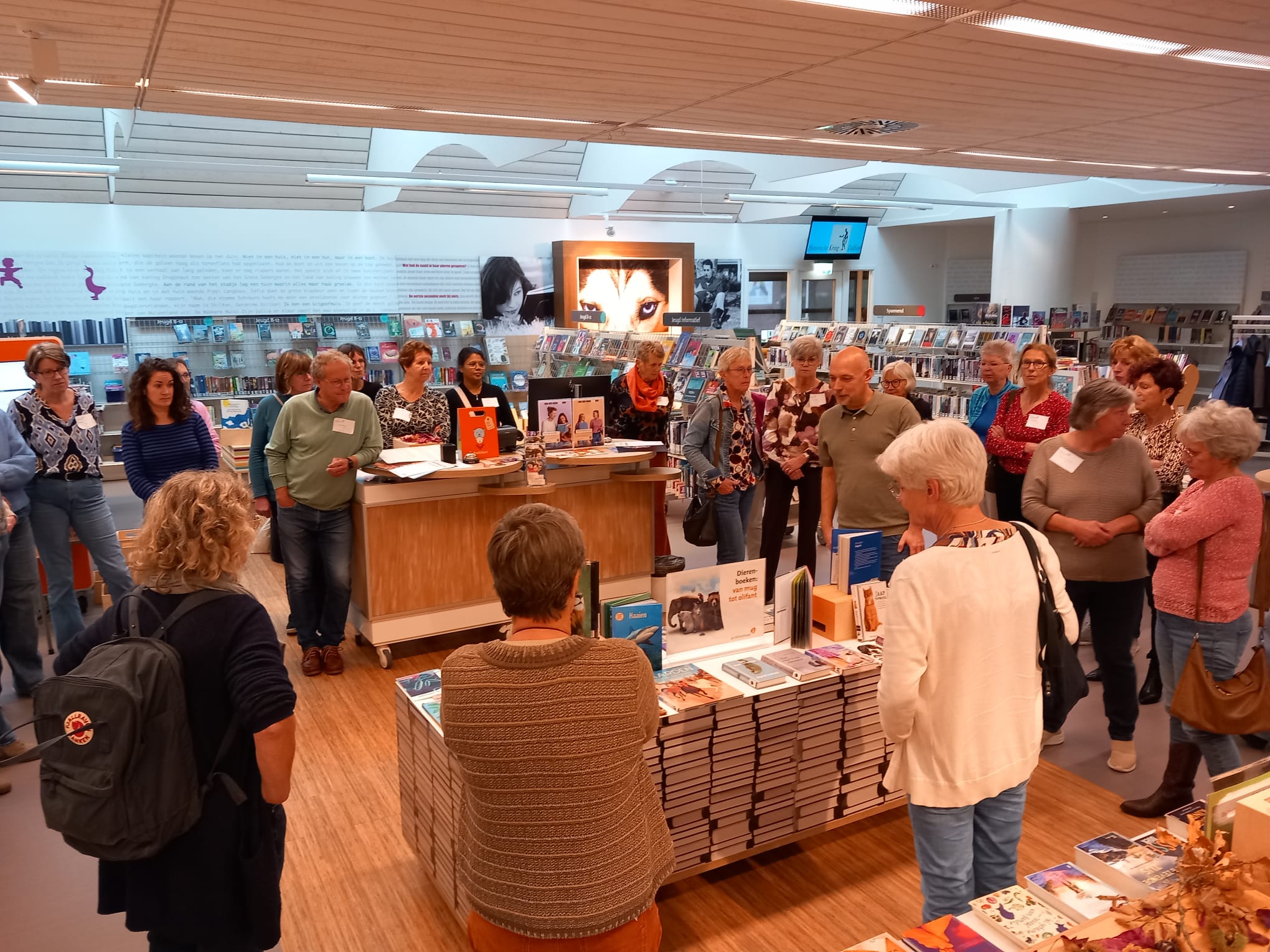 Vrijwilligers staan in de bibliotheek in Dalfsen rondom de thematafel.