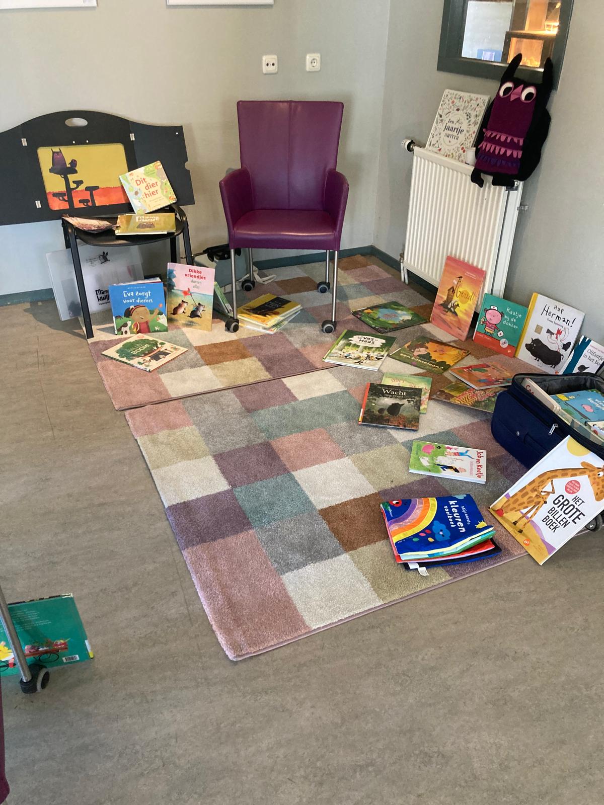 Stoel met daaromheen allerlei prentenboeken op een groot, geblokt kleed