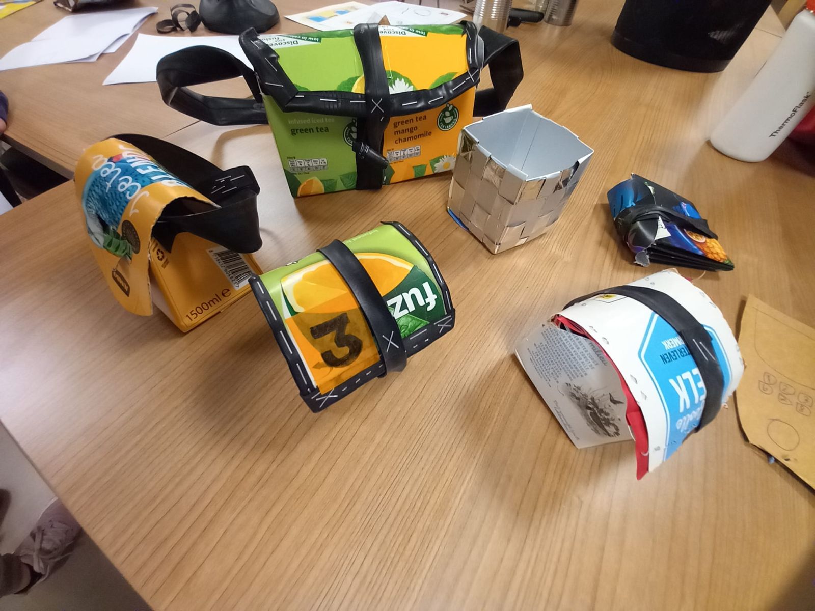 Verschillend items, zoals een tasje, bakje, kistje en portemonnee, gemaakt van verpakkingsmateriaal zoals sappakken en melkpakken