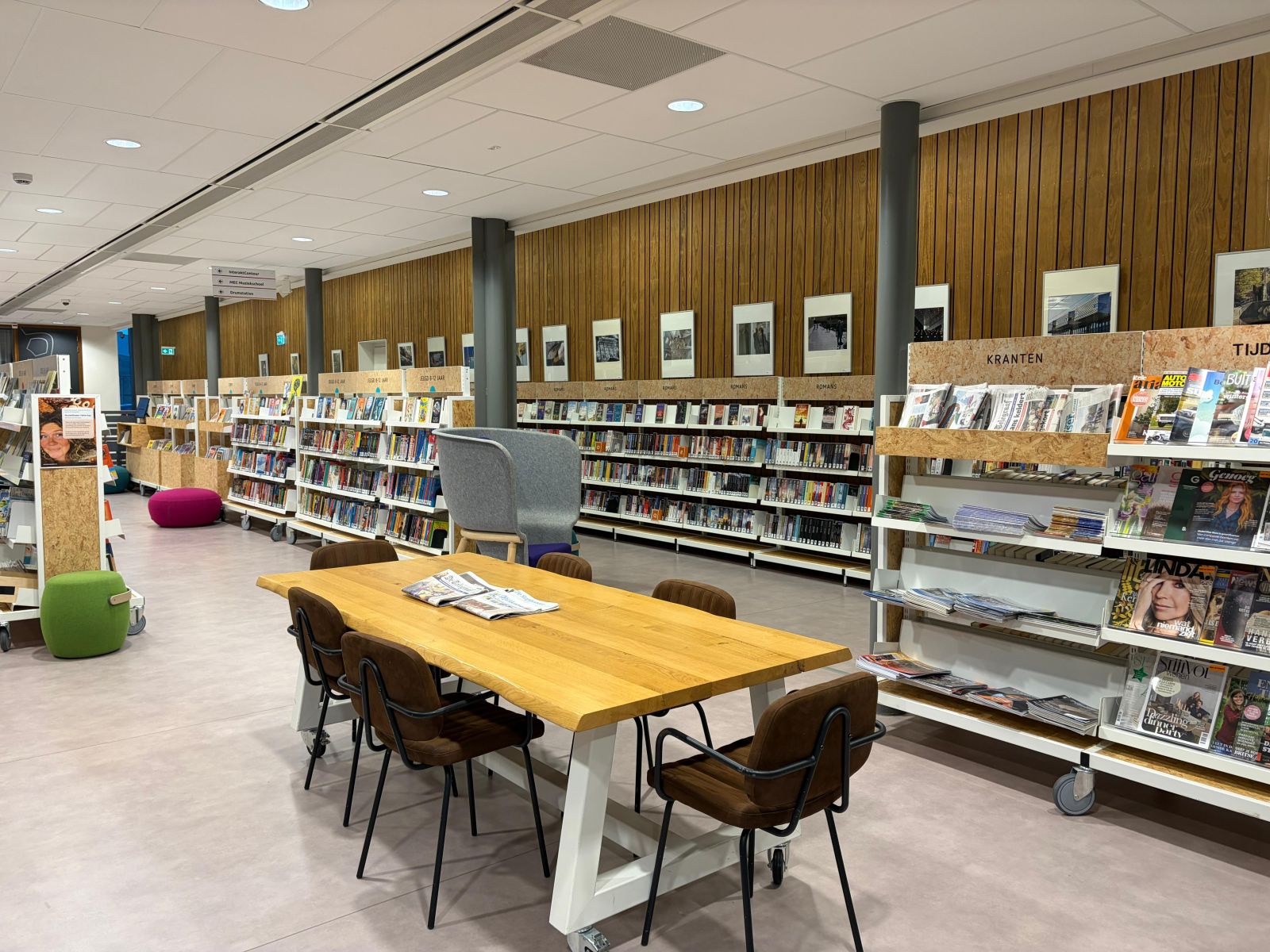 Grote tafel met tijdschriften erop en stoelen erom heen in Bibliotheek Nieuwleusen