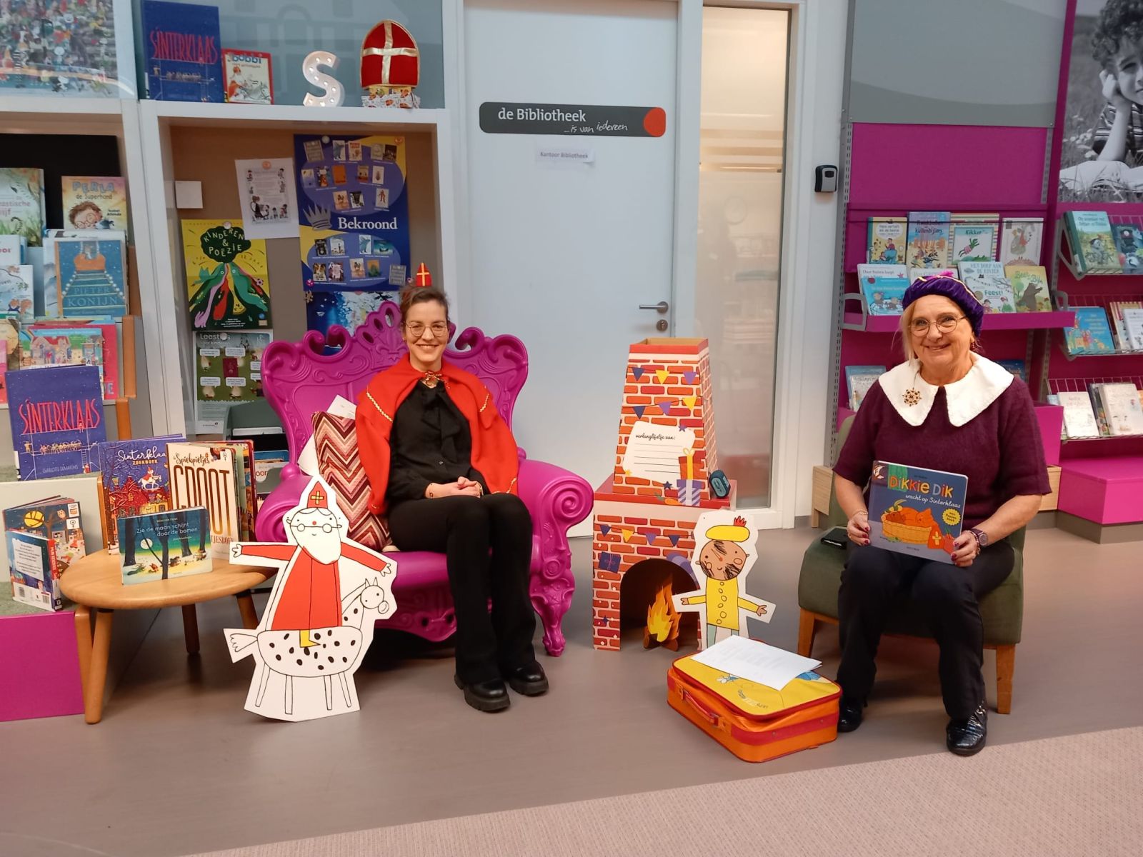 Twee vrijwilligers verkleed als Sinterklaas en Piet in afwachting om kinderen te gaan voorlezen
