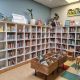 Kasten en manden met kinderboeken, vrolijk aangekleed met planten en knuffels.