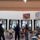 Twee medewerkers van de bibliotheek staat voor een groep kinderen uit te leggen