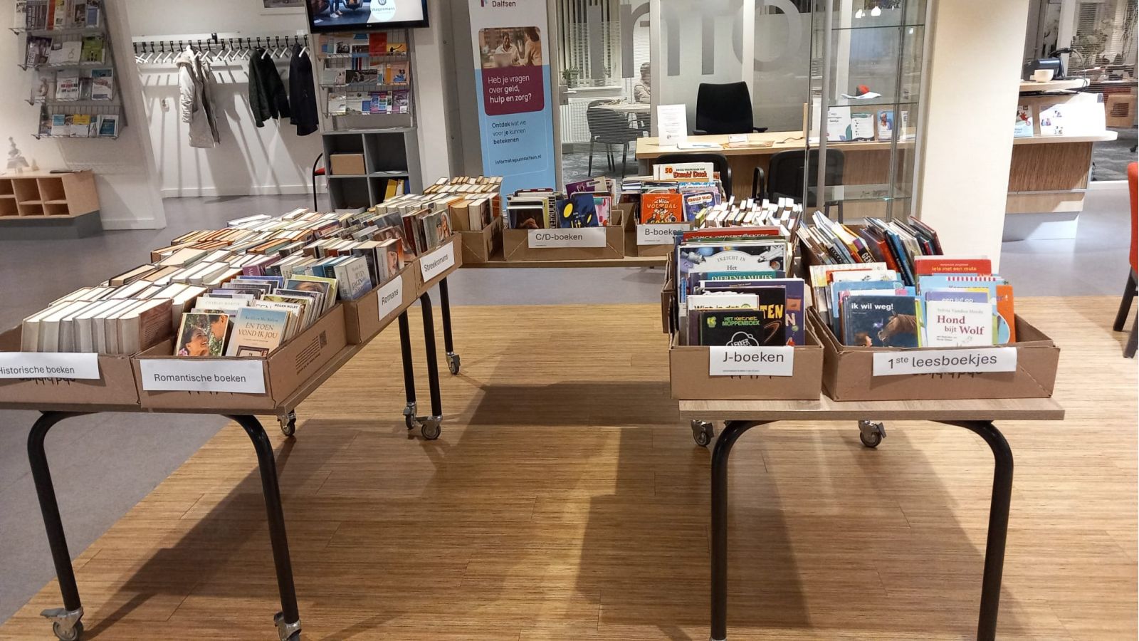 Tafel met dozen waarin boeken zitten van verschillende genres die te koop zijn.