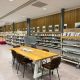 Grote tafel met tijdschriften erop en stoelen erom heen in Bibliotheek Nieuwleusen